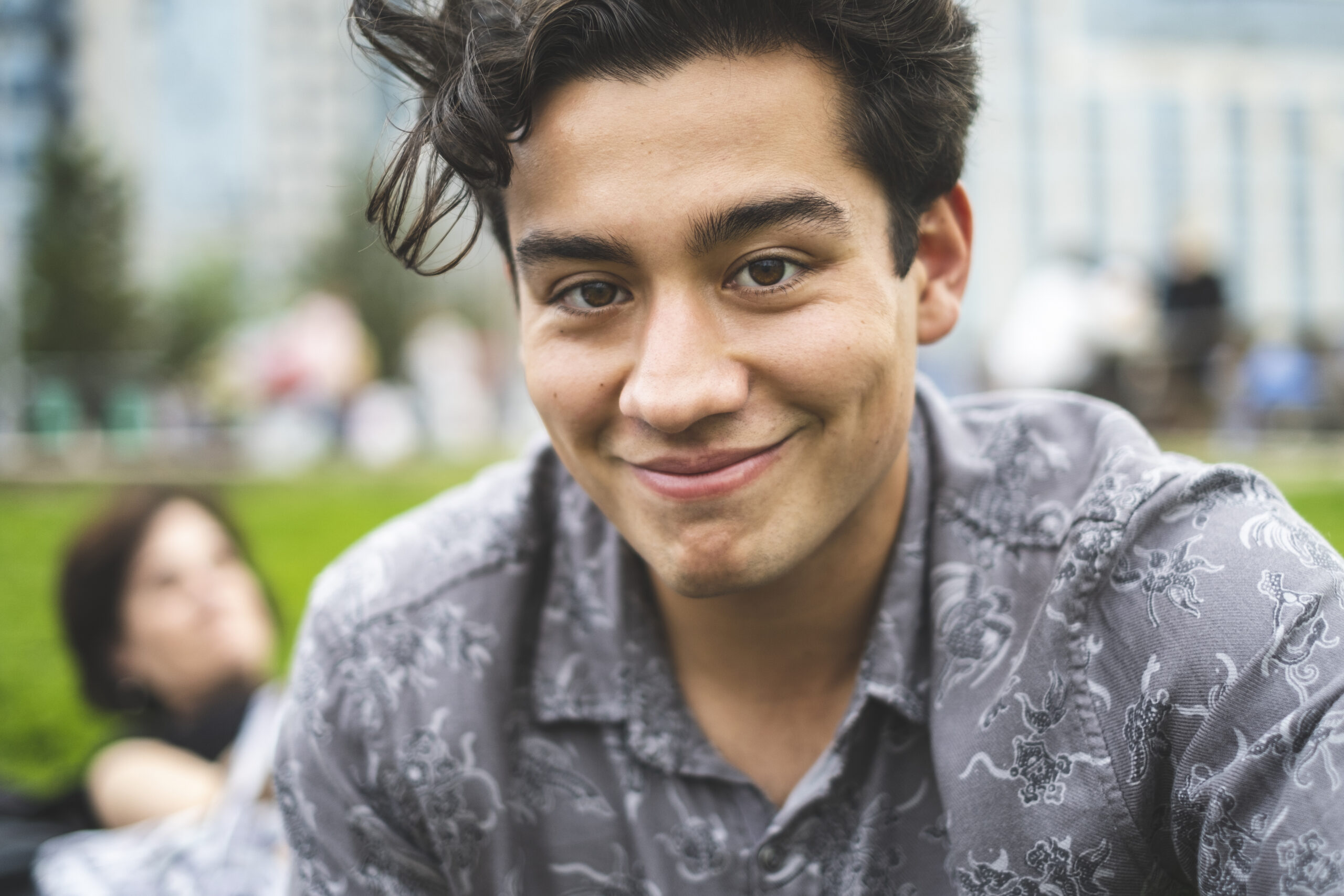 Handsome young man outside in park smiling