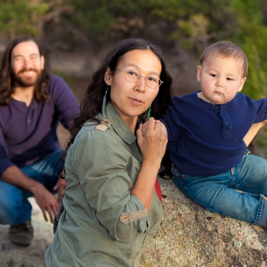 Young multicultural family in nature - shallow DOF - focus on mother &amp; baby