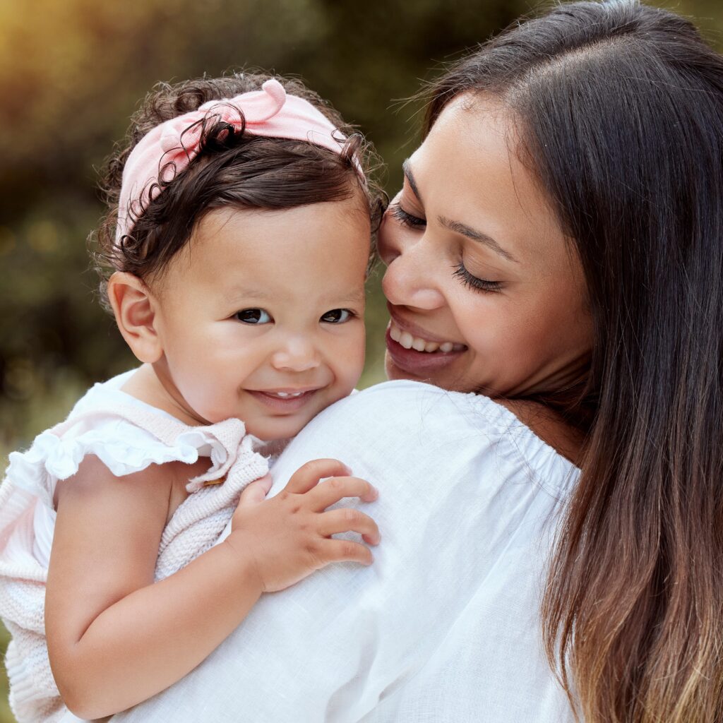 Young Latinx mother holding little girl.