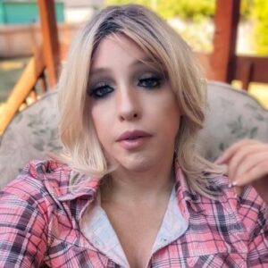 echoe reed sits in chair, pink plaid shirt