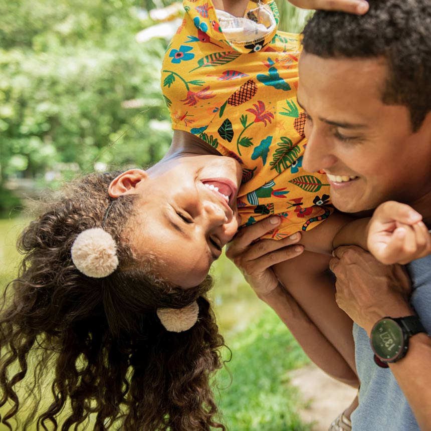 Father with daughter on shoulders playing and laughing.