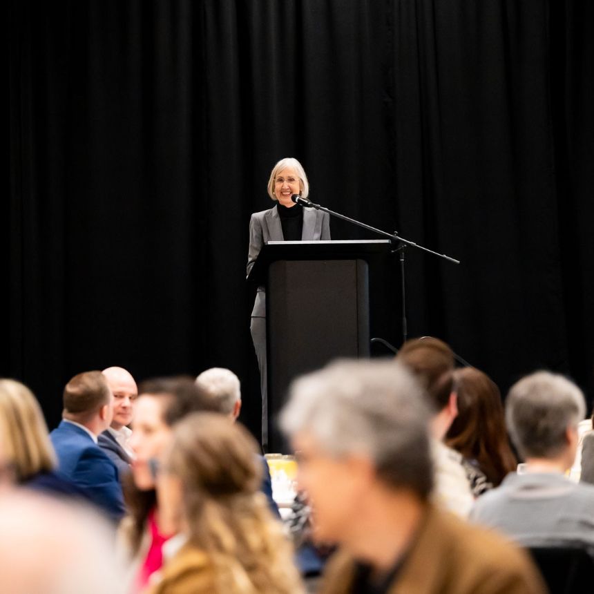 Mary Monnat speaks at the podium at LifeWorks NW's annual Something to Talk About fundraising breakfast.